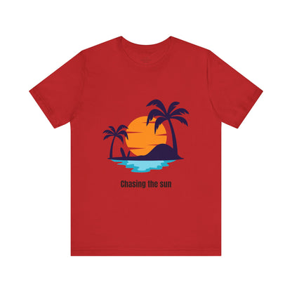 Bold red "Chasing the Sun" T-shirt with a tropical island print. Stylish, comfy, and great for beach vacations and everyday wear. Soft cotton crew neck, available in XS, S, M, L, XL, 2XL, 3XL. Luminous Gem Designs