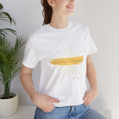 Woman wearing Crisp white "Walking Manifestation" T-shirt featuring a gold fireworks print. The perfect breathable tee for daily wear and empowerment. Sizes: XS, S, M, L, XL, 2XL, 3XL. Luminous Gem Designs.