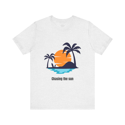 Versatile ash heather "Chasing the Sun" T-shirt with a tropical design. Ultra-soft and trendy for casual styling. Available in XS, S, M, L, XL, 2XL, 3XL. Luminous Gem Designs