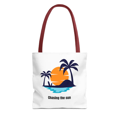 Stylish white Chasing the Sun tote bag with red handles, featuring a tropical island design with palm trees. Made from durable 100% polyester, perfect for carrying your essentials. Available in sizes 13"x13", 16"x16", 18"x18". Luminous Gem Designs.