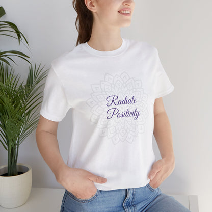 Woman wearing a white "Radiate Positivity" T-shirt with a spiritual mandala design. A timeless, feel-good tee perfect for meditation and mindfulness. Sizes: XS, S, M, L, XL, 2XL, 3XL. Luminous Gem Designs.