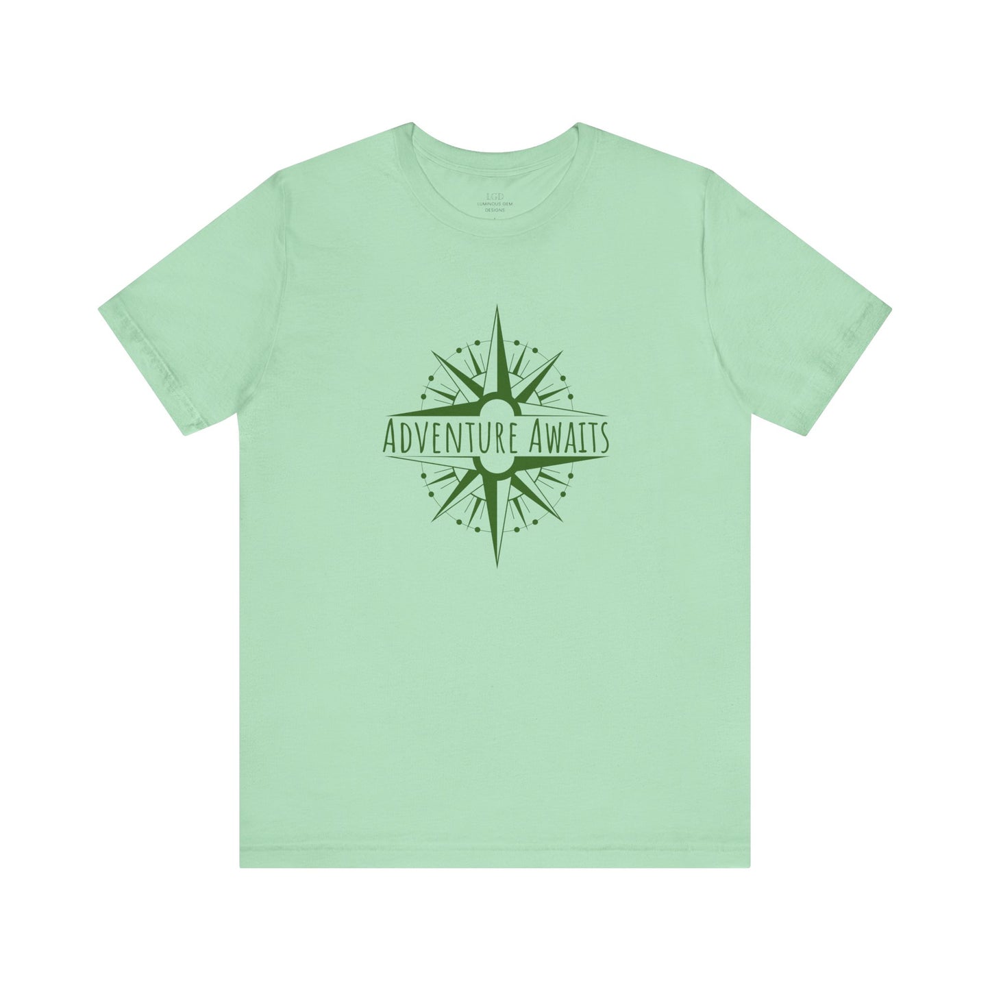 Mint green "Adventure Awaits" T-shirt featuring an earthy-toned compass print. A must-have for nature lovers, hikers, and wanderers. Sizes: XS, S, M, L, XL, 2XL, 3XL. Luminous Gem Designs.