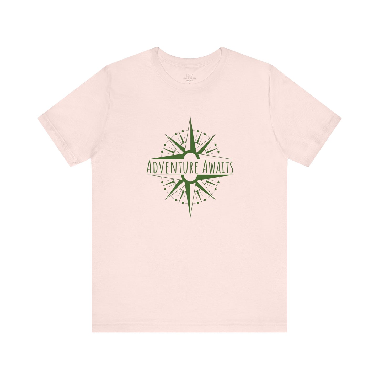 Soft pink "Adventure Awaits" T-shirt with a trendy compass graphic. A comfortable and breathable tee for explorers who love stylish travel gear. Sizes: XS, S, M, L, XL, 2XL, 3XL. Luminous Gem Designs.