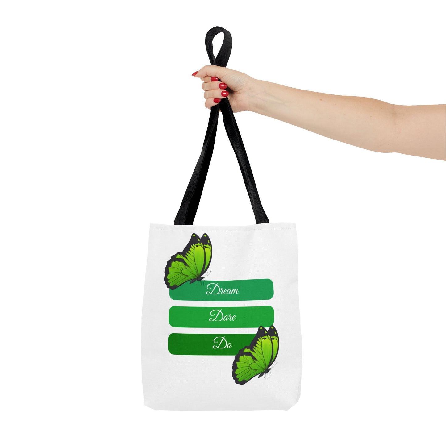 Hand holding Elegant white Dream, Dare & Do tote bag with black handles, featuring a motivational design with butterflies and a green-toned background. This durable 100% polyester tote is perfect for students, professionals, or nature lovers. Available in sizes 13"x13", 16"x16", 18"x18". Luminous Gem Designs.